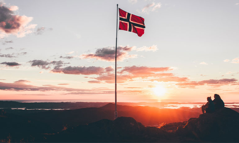 Noorse vlag op een klif in Bergen, Noorwegen