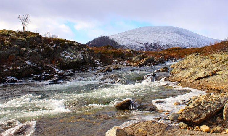 Rivier met besneeuwde berg op de achtergrond